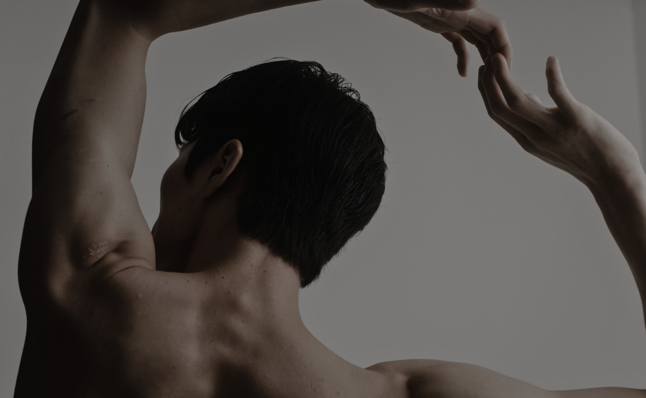 Hombre de espaldas con silueta ágil y delicada dando paso a la visibilidad de la vulnerabilidad de la piel con su cuerpo